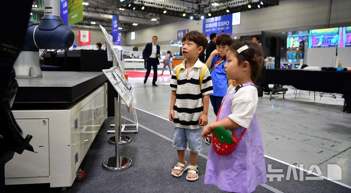 [광주=뉴시스] 이현행 기자 = 25일 오후 광주 서구 김대중컨벤션센터에서 열린 2025 광주미래산업엑스포에서 아이들이 AI로봇을 관람하고 있다. 2025.06.25 lhh@newsis.com