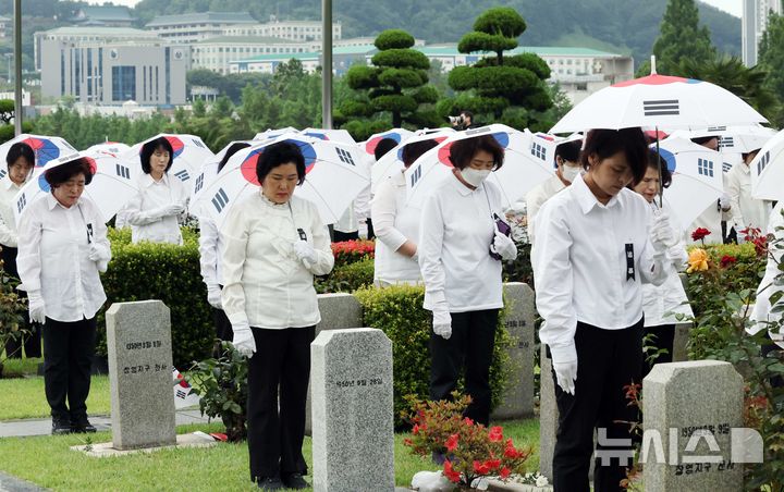 [부산=뉴시스] 하경민 기자 = '제75주년 6·25전쟁 참전 유엔전몰용사 추모제'가 열린 25일 부산 남구 유엔기념공원에서 참석자들이 전몰장병묘역에 헌화한 뒤 묵념을 하고 있다.유엔기념공원에는 총 14개국 2332명의 유엔군 전몰장병이 잠들어 있다. 2025.06.25. yulnetphoto@newsis.com