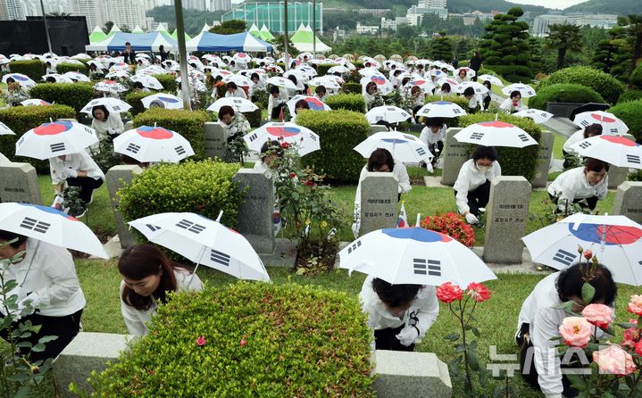 [부산=뉴시스] 하경민 기자 = '제75주년 6·25전쟁 참전 유엔전몰용사 추모제'가 열린 25일 부산 남구 유엔기념공원에서 참석자들이 전몰장병묘역에 헌화하고 있다.유엔기념공원에는 총 14개국 2332명의 유엔군 전몰장병이 잠들어 있다. 2025.06.25. yulnetphoto@newsis.com