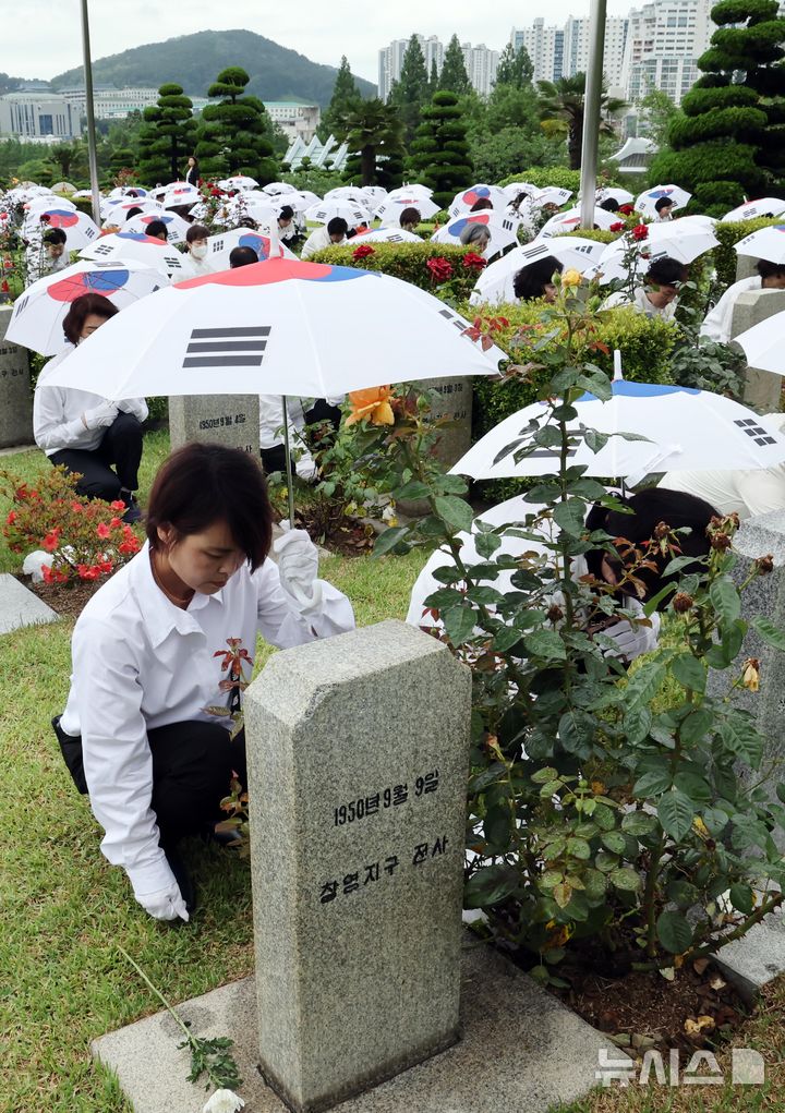 [부산=뉴시스] 하경민 기자 = '제75주년 6·25전쟁 참전 유엔전몰용사 추모제'가 열린 25일 부산 남구 유엔기념공원에서 참석자들이 전몰장병묘역에 헌화하고 있다.유엔기념공원에는 총 14개국 2332명의 유엔군 전몰장병이 잠들어 있다. 2025.06.25. yulnetphoto@newsis.com