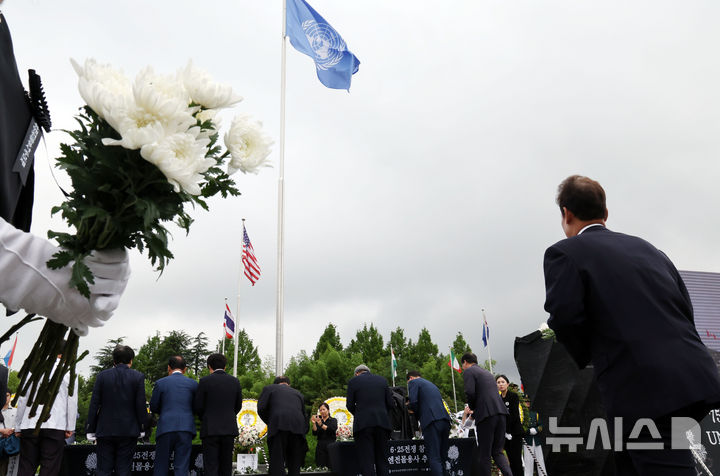 [부산=뉴시스] 하경민 기자 = '제75주년 6·25전쟁 참전 유엔전몰용사 추모제'가 열린 25일 부산 남구 유엔기념공원에서 참석자들이 전몰장병묘역에 헌화한 뒤 묵념을 하고 있다.유엔기념공원에는 총 14개국 2332명의 유엔군 전몰장병이 잠들어 있다. 2025.06.25. yulnetphoto@newsis.com