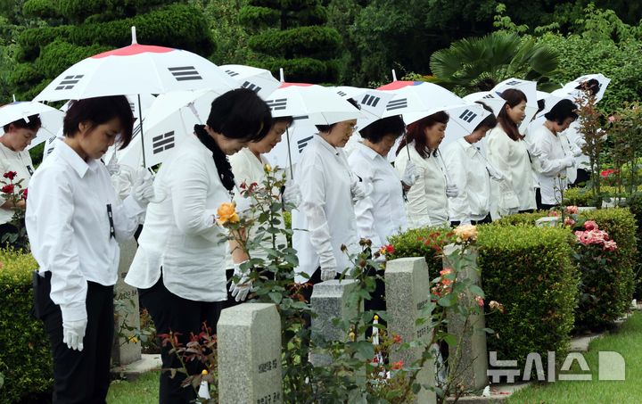 [부산=뉴시스] 하경민 기자 = '제75주년 6·25전쟁 참전 유엔전몰용사 추모제'가 열린 25일 부산 남구 유엔기념공원에서 참석자들이 전몰장병묘역에 헌화한 뒤 묵념을 하고 있다.유엔기념공원에는 총 14개국 2332명의 유엔군 전몰장병이 잠들어 있다. 2025.06.25. yulnetphoto@newsis.com