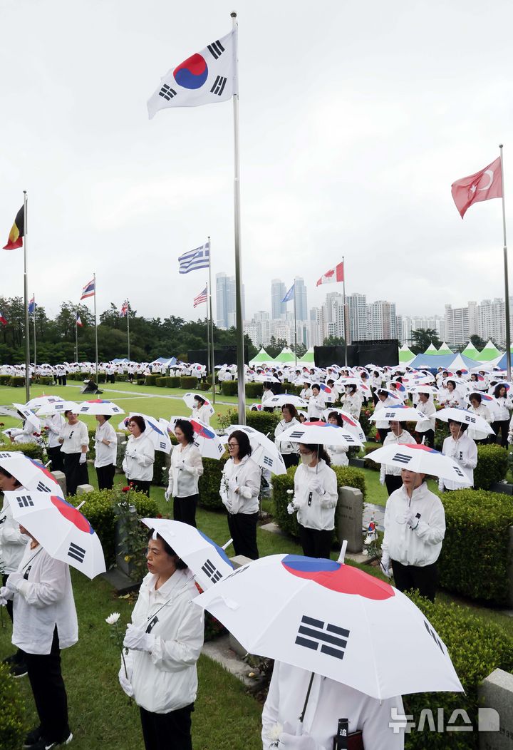 [부산=뉴시스] 하경민 기자 = '제75주년 6·25전쟁 참전 유엔전몰용사 추모제'가 열린 25일 부산 남구 유엔기념공원에서 참석자들이 전몰장병묘역에 헌화한 뒤 묵념을 하고 있다.유엔기념공원에는 총 14개국 2332명의 유엔군 전몰장병이 잠들어 있다. 2025.06.25. yulnetphoto@newsis.com