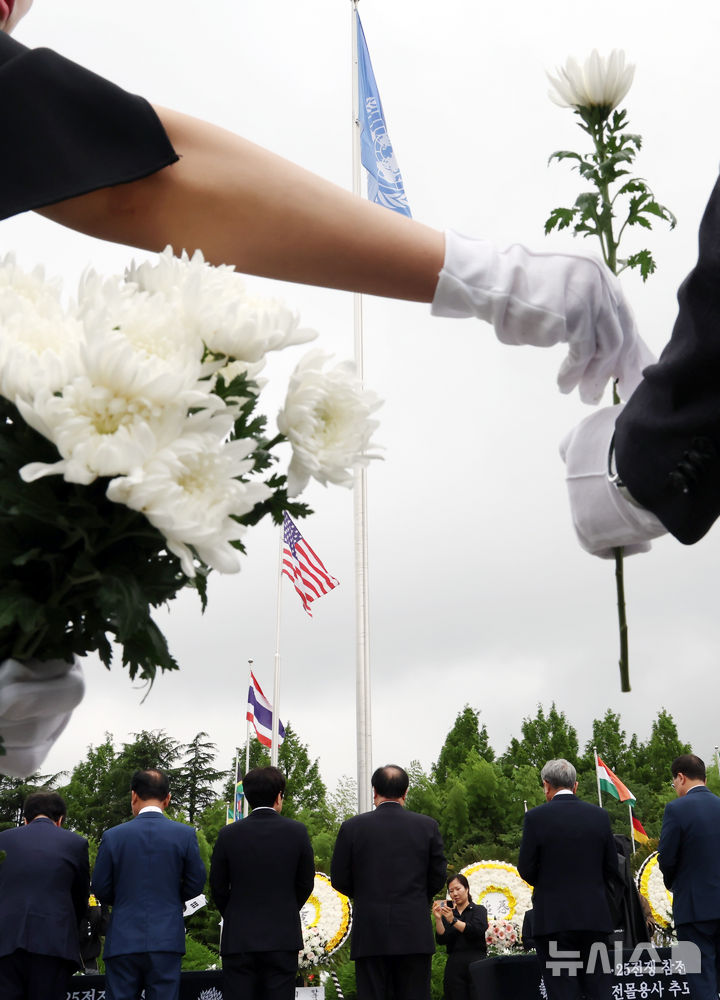 [부산=뉴시스] 하경민 기자 = '제75주년 6·25전쟁 참전 유엔전몰용사 추모제'가 열린 25일 부산 남구 유엔기념공원에서 참석자들이 전몰장병묘역에 헌화한 뒤 묵념을 하고 있다.유엔기념공원에는 총 14개국 2332명의 유엔군 전몰장병이 잠들어 있다. 2025.06.25. yulnetphoto@newsis.com