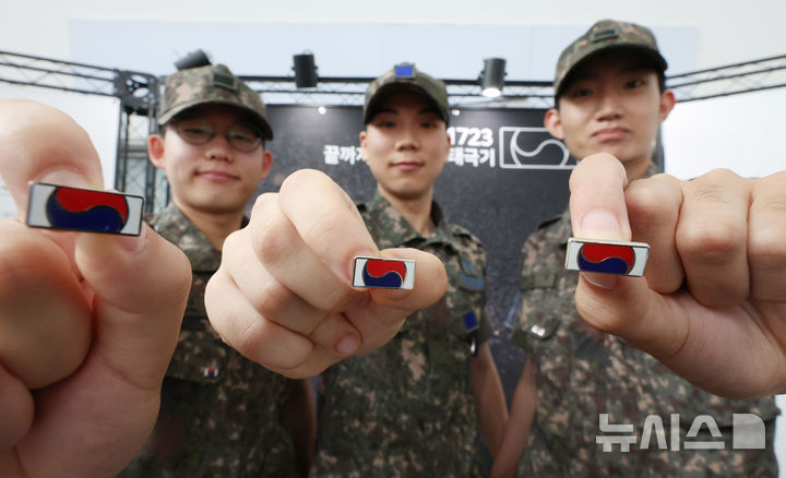 [서울=뉴시스] 김진아 기자 = 25일 서울 용산구 서울역 대합실에서 진행된 보훈부와 한화, 6·25전쟁 75주년 기념 '121723 끝까지 찾아야 할 태극기' 캠페인에서 군 장병들이 태극기 배지를 선보이고 있다. 보훈부는 6·25전쟁 75주년 계기 한화의 K9 자주포 철로 지금까지 돌아오지 못한 국군 전사자 121,723명의 호국영웅을 상징하는 12만 1,723개의 고유번호가 부여된 태극기 배지를 제작, 무료 배포했다. 2025.06.25. bluesoda@newsis.com