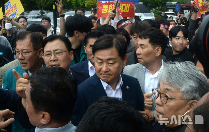 [완주=뉴시스] 김얼 기자 = 완주군민과의 대화를 위해 완주군청을 찾은 김관영(가운데) 전북특별자치도지사가 25일 전북 완주군청에서 대화를 거부하는 완주-전주 통합반대 완주군민대책위원회의 거센 항의에 장내를 빠져나오고 있다. 2025.06.25. pmkeul@newsis.com