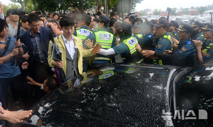 [완주=뉴시스] 김얼 기자 = 경찰관들이 25일 전북 완주군 완주군청을 빠져나가려는 김관영 전북특별자치도지사의 차량을 막아선 완주군민들 사이에서 차량 통제를 하고 있다. 2025.06.25. pmkeul@newsis.com