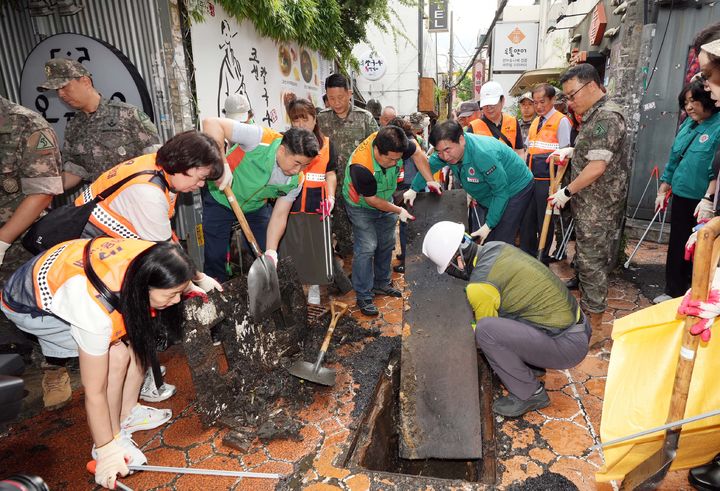 [부산=뉴시스] 부산 부산진구 서면 상가밀집지역에서 구청 공무원과 환경미화원, 도로보수원, 자율방재단, 의용소방대, 군 관계자 등이 집중호우로 인한 침수에 대비하기 위해 빗물받이에 쌓인 토사, 낙엽, 담배꽁초 등 퇴적물을 치우고 있다. (사진=뉴시스 DB). ***사진은 기사 내용과 무관합니다 *재판매 및 DB 금지