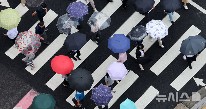 [서울=뉴시스] 이영환 기자 = 장마전선 영향으로 비가 내린 25일 오후 서울 중구 서울시청 인근에서 시민들이 우산을 쓰고 이동하고 있다. 2025.06.25. 20hwan@newsis.com
