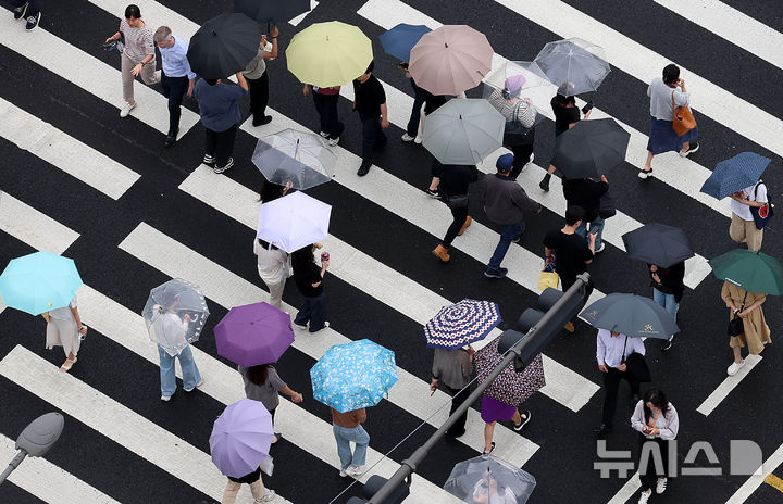 [서울=뉴시스] 이영환 기자 = 장마전선 영향으로 비가 내린 25일 오후 서울 중구 서울시청 인근에서 시민들이 우산을 쓰고 이동하고 있다. 2025.06.25. 20hwan@newsis.com