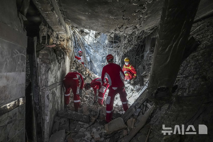 [테헤란=AP/뉴시스] 지난 24일(현지 시간) 이란 테헤란에서 구조대원들이 전날 이스라엘의 공습으로 파손된 에빈 교도소 일대를 수색하고 있다. 에빈 교도소에는 정치범 등이 수용되는 곳으로 알려져 있다. 2025.06.26.