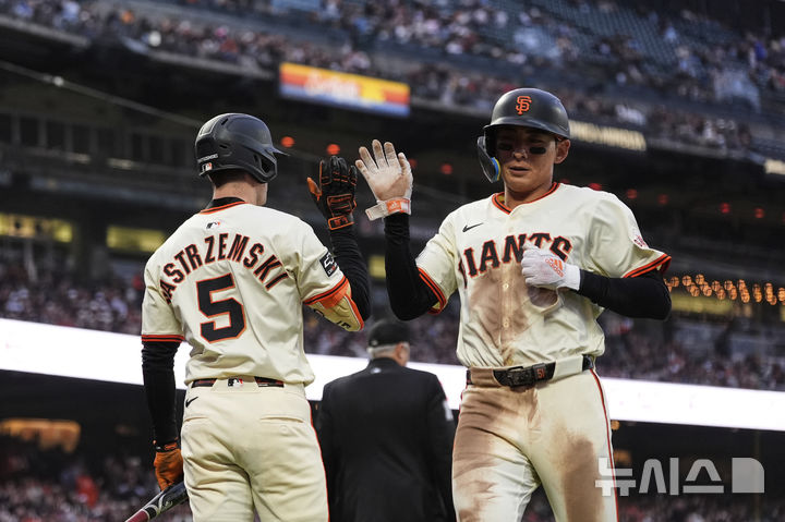 [샌프란시스코=AP/뉴시스] 샌프란시스코 자이언츠의 이정후(오른쪽)가 25일(현지 시간) 미 캘리포니아주 샌프란시스코 오라클 파크에서 열린 2025 메이저리그 마이애미 말린스와의 경기 5회 말 포볼 진루 후 크리스티안 코스의 희생플라이로 득점하고 있다. 2025.06.26.
