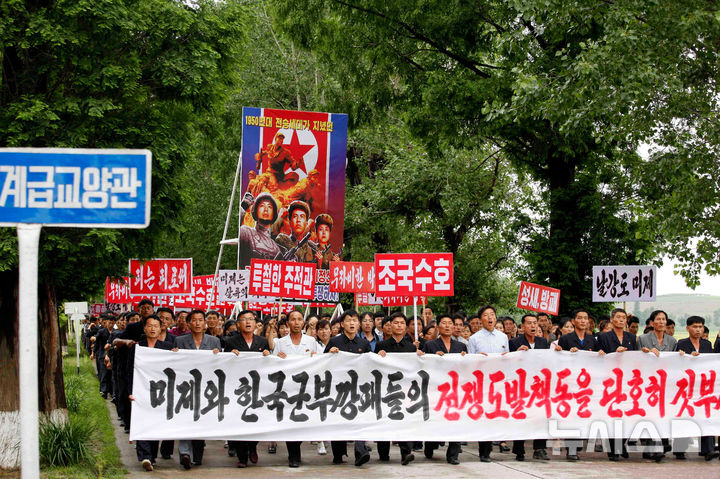 [신천=AP/뉴시스] 지난해 6월 25일 북한 황해남도 신천군에서 열린 '6·25 미제 반대 투쟁의 날' 군중 집회 참가자들이 현수막과 손팻말 등을 들고 구호를 외치고 있다. 2026.06.25.