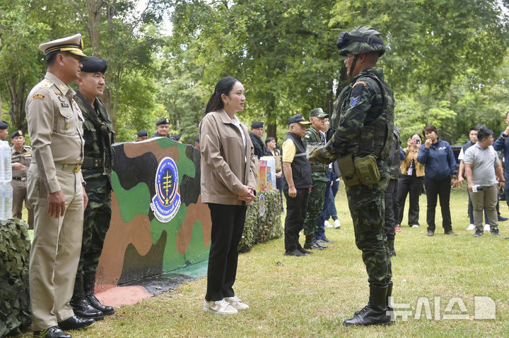[사깨오=AP/뉴시스] 패통탄 친나왓(가운데) 태국 총리가 지난 6월26일 태국 사깨오주의 군부대를 방문해 한 군인과 얘기하고 있다. 최근 캄보디아와의 국경 충돌이 악화하기 전 캄보디아 상원의장과의 통화에서 자국 군 지휘관을 폄하하는 발언이 유출되며 정치적 위기에 직면한 패통탄 총리는, 대국민 사과에 이어 국경 지역 군부대를 찾아 수습에 나섰다. 2025.07.25.