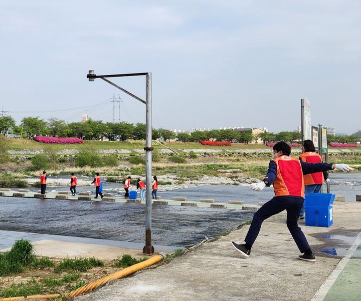  [영주=뉴시스] SK스페셜티 행복나눔봉사단이 26일 영주시 서천 일대에서 수질 정화를 위한 EM흙공을 상류에 투척하고 있다. (사진= SK스페셜티 제공) 2025.06.26. photo@newsis.com *재판매 및 DB 금지