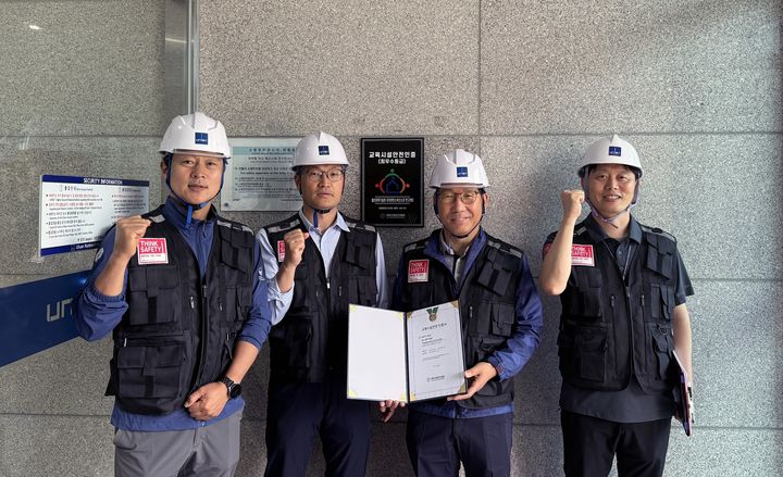 [울산=뉴시스] 구미현 기자 = 권용준 UNIST 안전시설관리본부장(왼쪽 세 번째)과 관계자들이 교육시설 안전인증 명판을 달고 기념촬영을 하고 있다. (사진=UNIST 제공) 2025.06.26. photo@newsis.com *재판매 및 DB 금지