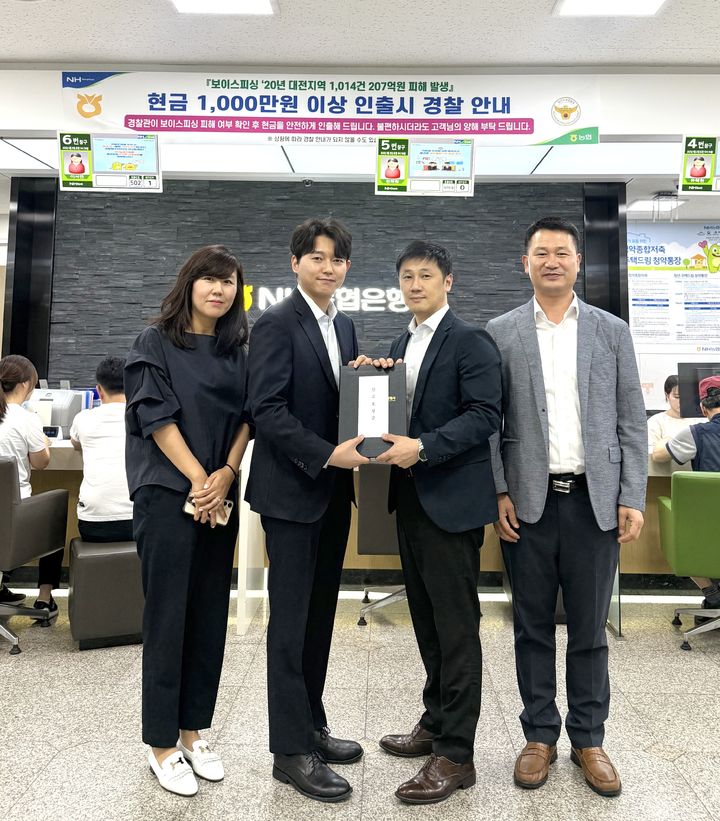 [대전=뉴시스]조명휘 기자 = NH농협은행 대전 서구 탄방동지점 직원들이 둔산경찰서로부터 보이스피싱 예방 감사장을 받고 기념사진을 찍고 있다. (사진= 농협 제공) 2025.06.26. photo@newsis.com *재판매 및 DB 금지