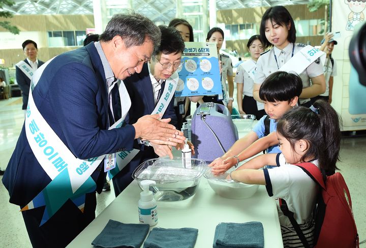 [서울=뉴시스] 이학재 인천국제공항공사 사장(맨 왼쪽)과 윤현덕 국립인천공항검역소 소장(왼쪽 두 번째)이 26일 '여름 휴가철 맞이 대국민 안전여행 캠페인' 일환으로 어린이 여객들에게 올바른 손 씻기 요령을 안내하고 있다. 2025.06.26. (사진=인천공항공사 제공) photo@newsis.com *재판매 및 DB 금지