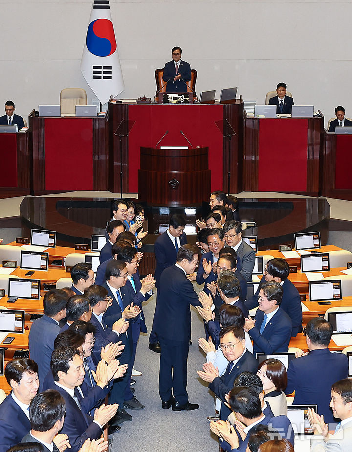 [서울=뉴시스] 고범준 기자 = 이재명 대통령이 26일 서울 여의도 국회 본회의장에서 추가경정예산(추경) 시정연설을 위해 입장하며 의원들과 악수하고 있다. 2025.06.26. bjko@newsis.com