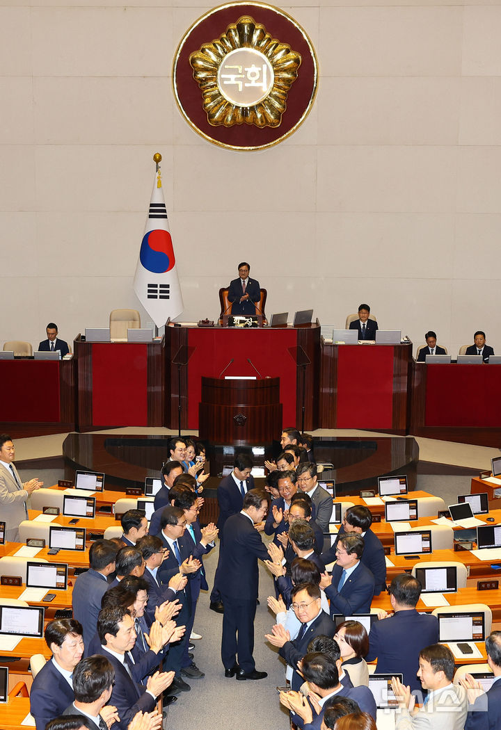 [서울=뉴시스] 고범준 기자 = 이재명 대통령이 26일 서울 여의도 국회 본회의장에서 추가경정예산(추경) 시정연설을 위해 입장하며 의원들과 악수하고 있다. 2025.06.26. bjko@newsis.com