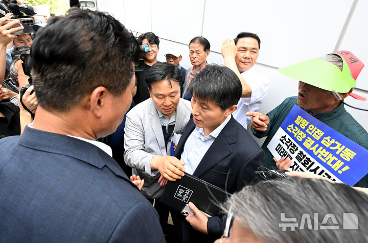 [광주=뉴시스] 김혜인 기자 = 26일 오후 광주 광산구 삼도동행정복지센터에 마련된 '광주시 자원회수시설(쓰레기 소각장) 설치사업 전략·기후환경평가 초안 주민설명회' 공청회장 앞에서 삼도동 주민과 인근 전남 함평 주민이 광주시 관계자를 향해 강하게 반발하고 있다. 2025.06.26. hyein0342@newsis.com