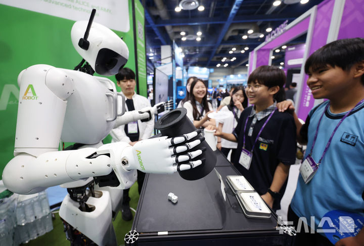[서울=뉴시스] 김진아 기자 = 26일 서울 강남구 코엑스에서 열린 '넥스트라이즈 2025'에서 학생들이 에이로봇의 휴머노이드 로봇 '앨리스4'와 주사위 게임을 하고 있다. 2025.06.26. bluesoda@newsis.com