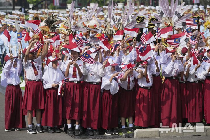 [자카르타=AP/뉴시스] 27일(현지 시간) 인도네시아 자카르타 메르데카궁에서 열린 안와르 이브라힘 말레이시아 총리 환영 행사에서 인도네시아 초등학생들이 양국 국기를 흔들고 있다. 2025.06.27.