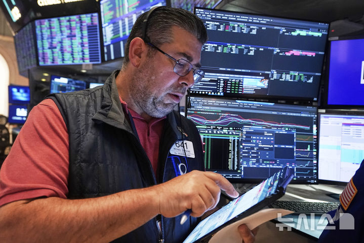 [뉴욕=AP/뉴시스]27일(현지 시간) 뉴욕증권거래소(NYSE)에서 트레이더 마이클 캐폴리노가 업무를 보고 있다. 2025.06.28.