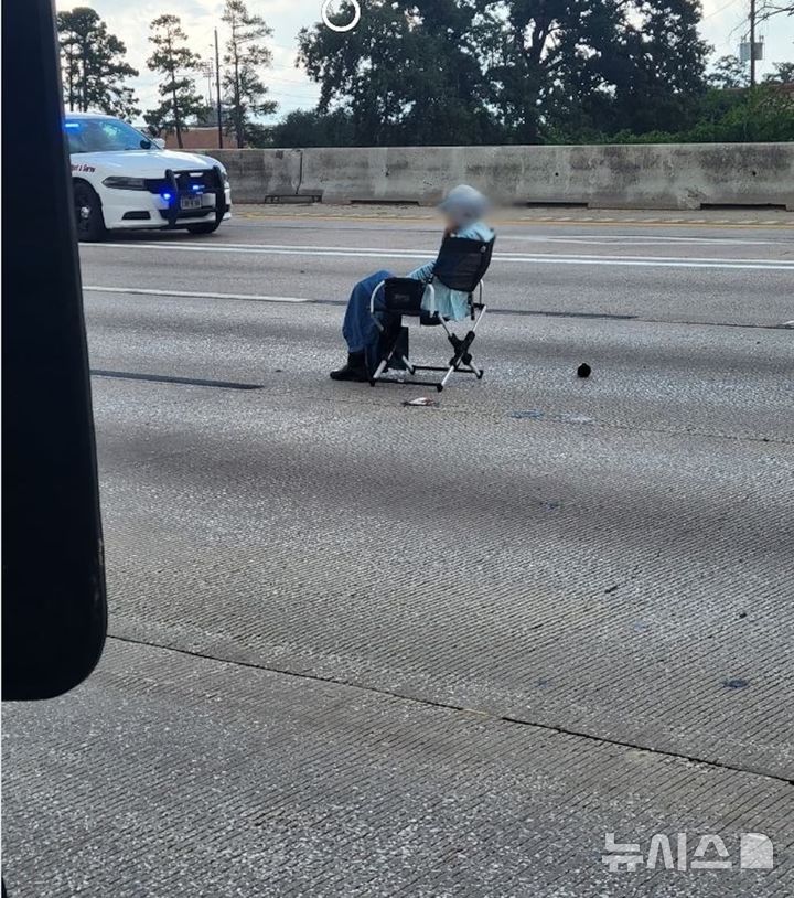 [서울=뉴시스] 텍사스 고속도로 가운데 여성이 총을 자신의 머리에 겨눈 채 앉아있다. (사진=ABC뉴스) 06.27. 