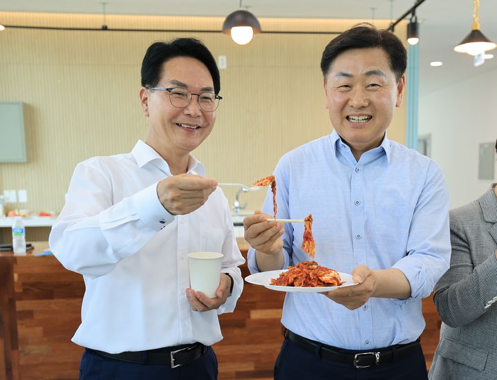 [고창=뉴시스] 27일 열린 '고창군 사시사철 김치특화 농생명산업지구' 핵심 거점시설 '발효 및 식품산업육성지원센터 준공식', 행사 후 내부 시설을 둘러보던 심덕섭 고창군수(왼쪽)와 김관영 전북도지사(오른쪽)가 고창김치를 맛보고 있다. *재판매 및 DB 금지