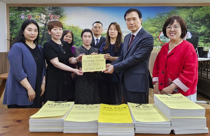 [화성=뉴시스] 27일 오후 화성반월초등학교에서 열린 간담회에서 임태희 경기도교육감이 화성 열병합발전소 건립 반대 의견을 담은 학부모 서명서를 전달받고 있다. 학부모들은 발전소 건립 철회를 촉구했다. (사진=경기도교육청 제공) 2025.06.27. photo@newsis.com *재판매 및 DB 금지