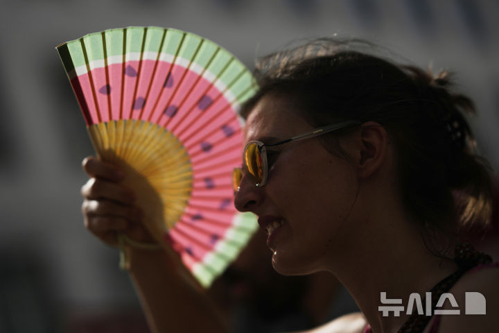 <font style="vertical-align: inherit;"><font style="vertical-align: inherit;">[리스본=AP/뉴시스] 28일(현지 시간) 포르투갈 리스본에서 열린 주택난에 항의하는 시위에 참가한 참가자가 부채로 햇빛을 가리고 있다. 2025.06.30.</font></font>