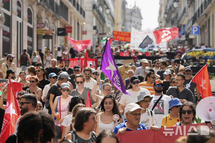 [AP/뉴시스] 포르투갈 수도 리스본에서 지난달 28일 고온의 뜨거운 날씨 속에 주택 위기에 항의하는 시위대가 행진하고 있다