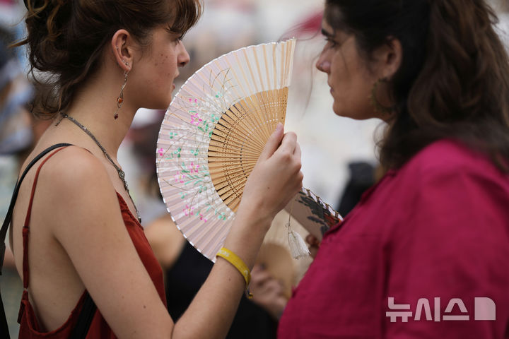 <font style="vertical-align: inherit;"><font style="vertical-align: inherit;">[리스본=AP/뉴시스] 28일(현지 시간) 포르투갈 리스본에서 열린 주택난에 항의하는 시위에 참가한 참가자들이 부채로 더위를 식히고 있다. 2025.06.30.</font></font>