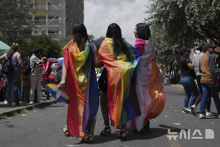 [키토=AP/뉴시스] 28일(현지 시간) 에콰도르 키토에서 무지개 깃발을 몸에 두른 사람들이 프라이드 퍼레이드에참여하고 있다. 이번 행사는 '6월 성소수자(LGBTQ+) 인권의 달'을 마무리하는 일환으로 열렸다. 2025.06.29.
