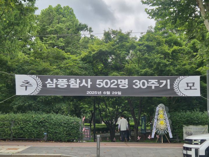 [서울=뉴시스] 이명동 기자 = 삼풍백화점 붕괴 참사 30주기를 맞은 29일 오전 서울 서초구 양재시민의숲 내부 삼풍백화점 붕괴 참사 위령탑으로 가는 길에 30주기 안내 현수막이 붙어있다. 2025.06.29. ddingdong@newsis.com *재판매 및 DB 금지