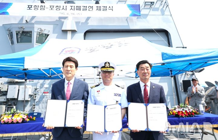 [포항=뉴시스] 송종욱 기자 = 경북 포항시는 지난 28일 대한민국 해군 1함대사령부 포항함(FFG)과 자매결연을 했다. 사진은 포항함 비행갑판에서 자매결연을 한 후 이강덕(왼쪽부터) 포항시장, 이준규 포항함장 중령, 김일만 포항시의회 의장이 기념 촬영하는 모습. (사진=포항시 제공) 2025.06.29. photo@newsis.com