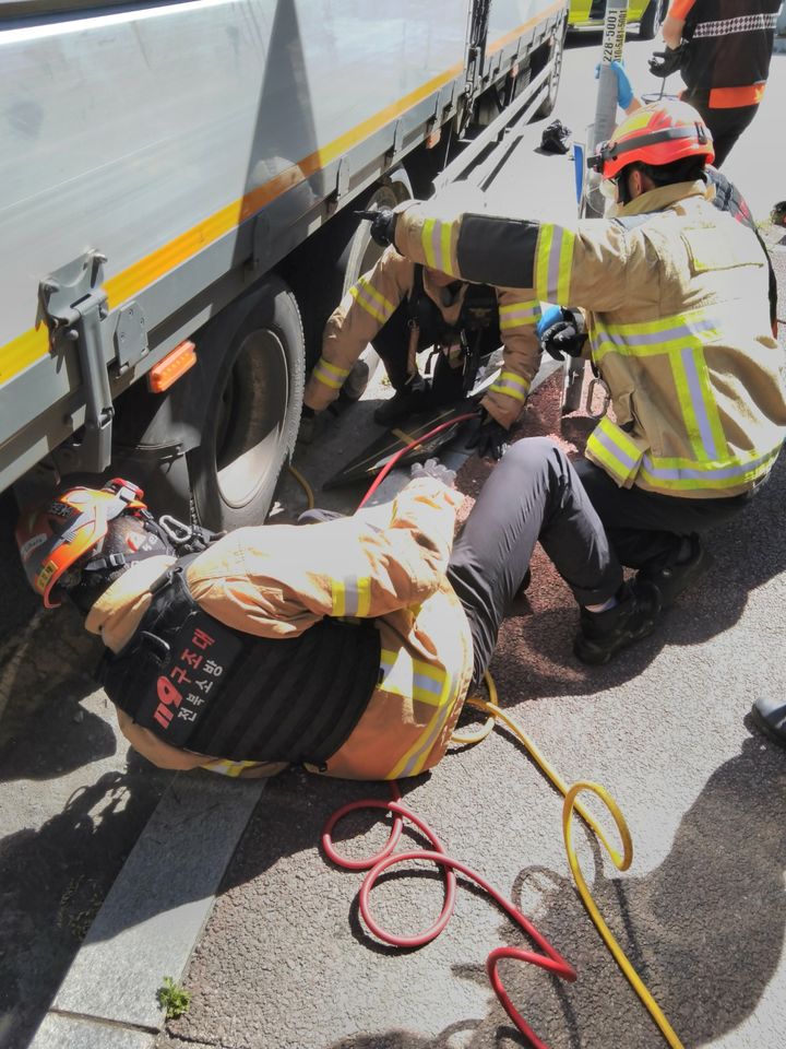 [전주=뉴시스] 29일 오전 9시35분께 전북 전주시 완산구 효자동의 한 도로에서 6.5t 탑차를 정비하던 A(60대)씨가 차량에 깔려 소방대원이 구조 작업을 하고 있다. (사진=전북도소방본부 제공) 2025.06.29. photo@newsis.com *재판매 및 DB 금지