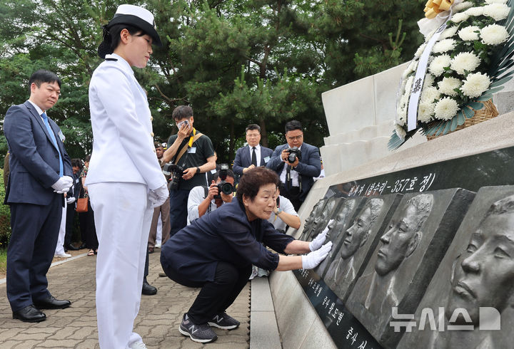 [평택=뉴시스] 황준선 기자=29일 경기도 평택시 해군 제2함대사령부에서 열린 '제2연평해전 승전 23주년 기념식'에서 고 조천형 상사 모친과 학군 70기로 임관한 딸 조시은 해군 소위가 얼굴 부조상을 바라보고 있다.(공동취재) 2025.06.29. photo@newsis.com