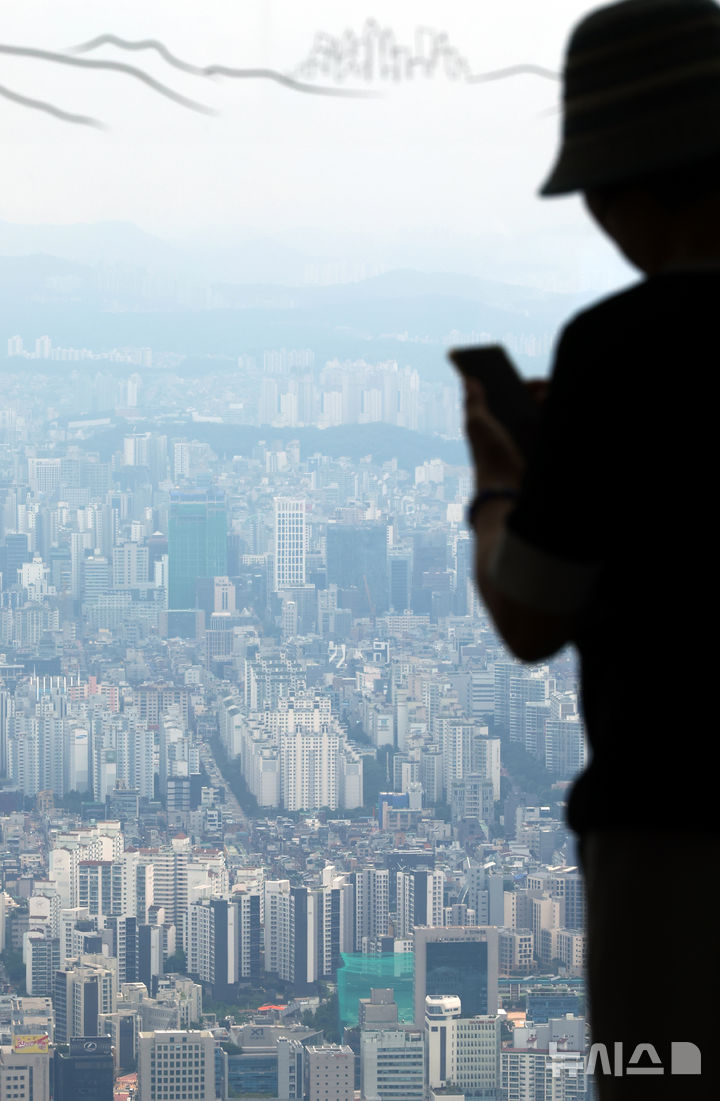 [서울=뉴시스] 박주성 기자 = 정부가 수도권과 규제지역의 주택담보대출 한도를 6억원으로 제한하는 초강수 조치를 펴면서 서울 아파트의 74%가 주담대 제한 영향권에 들게 된다는 분석이 나왔다. 부동산R114의 수도권 아파트 평균 시세를 보면 서울 전체 25개 구 가운데 18개 구의 대출액이 종전보다 줄어들 것으로 예상했다. 사진은 29일 서울 송파구 롯데월드타워 전망대 서울스카이에서 바라본 서울시내 아파트의 모습. 2025.06.29. park7691@newsis.com