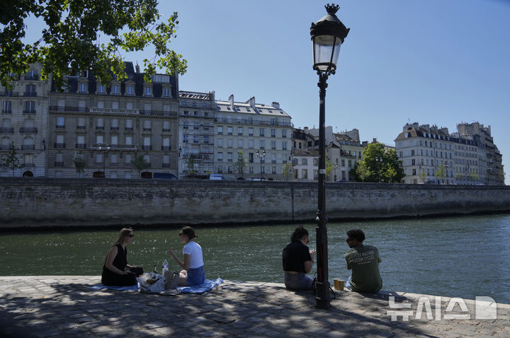 <font style="vertical-align: inherit;"><font style="vertical-align: inherit;">[파리=AP/뉴시스] 29일(현지 시간) 프랑스 파리 센 강에서 시민들이 햇빛을 피해 그늘에 앉아 있다. 2025.06.30.</font></font>