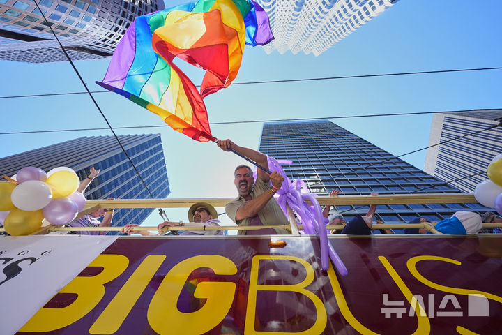 [샌프란시스코=AP/뉴시스] 29일(현지 시간) 미 캘리포니아주 샌프란시스코에서 열린 프라이드 퍼레이드 참가자가 무지개 깃발을 펄럭이며 행진하고 있다. 매년 6월은 '세계 성소수자 프라이드의 달'로 세계 곳곳에서 기념행사가 열린다. 2025.06.30.