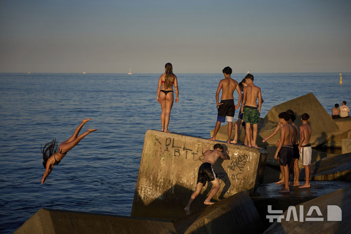 [바르셀로나=AP/뉴시스] 더운 날씨를 보인 29일(현지 시간) 스페인 바르셀로나 인근 해변에서 어린이들이 바다로 뛰어들고 있다. 2025.06.30.