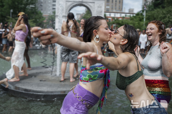 [뉴욕=AP/뉴시스] 29일(현지 시간) 미 뉴욕주 뉴욕에서 열린 프라이드 퍼레이드를 마친 여성들이 워싱턴 스퀘어 파크에 모여 입 맞춤하고 있다. 매년 6월은 '세계 성소수자 프라이드의 달'로 세계 곳곳에서 기념행사가 열린다. 2025.06.30.