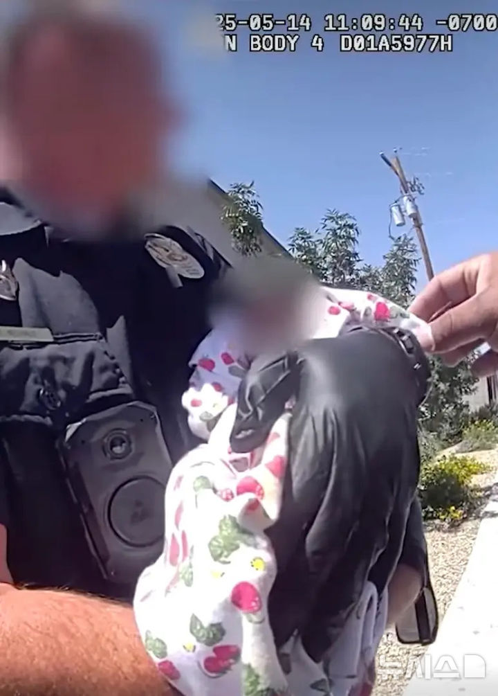 [서울=뉴시스] 美 경찰이 구출한 아이를 안고 있다. (사진=뉴욕포스트) 06.29. 