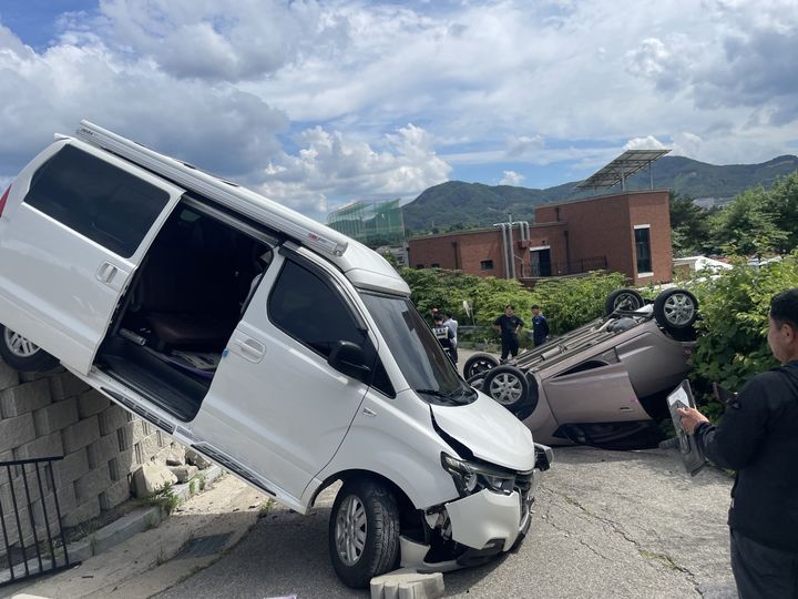 [아산=뉴시스] 30일 오후 2시26분께 충남 아산시 신창면의 한 까페 주차장에서 승합차와 경차가 충돌한 후 옹벽 난간 아래로 추락해 이중 경차가 전복됐다. (사진=아산소방서 제공) 2025.06.30. photo@newsis.com *재판매 및 DB 금지