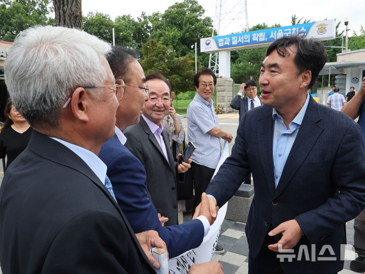[서울=뉴시스] 배훈식 기자 = 정당법 위반 혐의로 수감중이던 윤관석 전 의원이 30일 오전 1년 10개월여 만에 가석방돼 경기 의왕시 서울구치소를 나서며 지지자들과 악수하고 있다. 윤 전 의원은 더불어민주당 전당대회 돈봉투 사건으로 징역 2년형을 선고받고 복역했다. 2025.06.30. dahora83@newsis.com