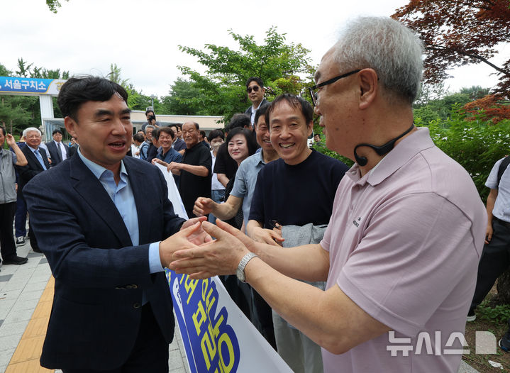 [서울=뉴시스] 배훈식 기자 = 정당법 위반 혐의로 수감중이던 윤관석 전 의원이 30일 오전 1년 10개월여 만에 가석방돼 경기 의왕시 서울구치소를 나서며 지지자들과 악수하고 있다. 윤 전 의원은 더불어민주당 전당대회 돈봉투 사건으로 징역 2년형을 선고받고 복역했다. 2025.06.30. dahora83@newsis.com