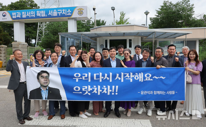 [서울=뉴시스] 배훈식 기자 = 정당법 위반 혐의로 수감중이던 윤관석 전 의원이 30일 오전 1년 10개월여 만에 가석방돼 경기 의왕시 서울구치소를 나와 지지자들과 기념촬영을 하고 있다. 윤 전 의원은 더불어민주당 전당대회 돈봉투 사건으로 징역 2년형을 선고받고 복역했다. 2025.06.30. dahora83@newsis.com