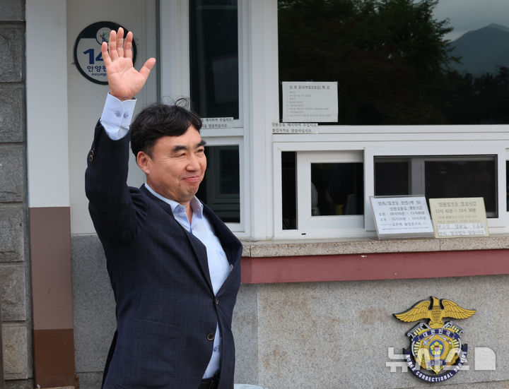 [서울=뉴시스] 배훈식 기자 = 정당법 위반 혐의로 수감중이던 윤관석 전 의원이 30일 오전 1년 10개월여 만에 가석방돼 경기 의왕시 서울구치소를 나서며 지지자들을 향해 손을 흔들고 있다. 윤 전 의원은 더불어민주당 전당대회 돈봉투 사건으로 징역 2년형을 선고받고 복역했다. 2025.06.30. dahora83@newsis.com